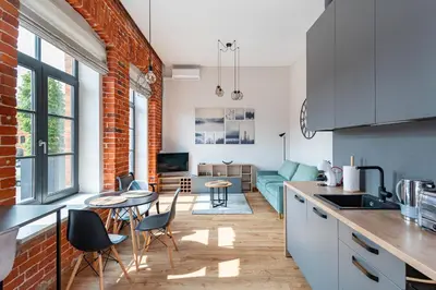 a kitchen and living room with a brick wall at Shanti barracks apartment #3 by Polo Apartments in Kaunas