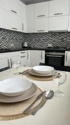 a kitchen table with two plates and silverware on it at Rugilės lelijų apartamentai in Birštonas