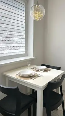 a white table with two chairs and a plate and glasses at Rugilės lelijų apartamentai in Birštonas