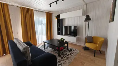 a living room with a couch and a chair and a television at Gervių takas 1