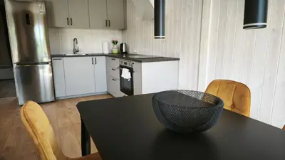 a kitchen with a black table and chairs and a counter at Gervių takas 1