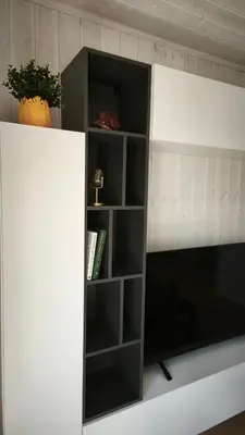 a white cabinet with black shelves in a room at Gervių takas 1