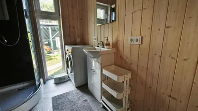 a bathroom with a sink and a washing machine at Gervių takas 1