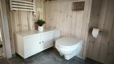 a bathroom with a toilet and a plant in a vase at Gervių takas 1