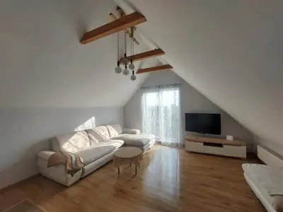 a living room with a couch and a tv at Fryko apartamentai Kaune in Kaunas