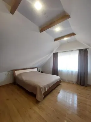 a white bedroom with a bed and a window at Fryko apartamentai Kaune in Kaunas