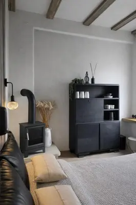 a living room with a couch and a black dresser at Central Downtown Terrace Studio in Šiauliai