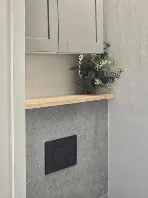 a fireplace with a wooden shelf and white cabinets at Central Downtown Terrace Studio in Šiauliai