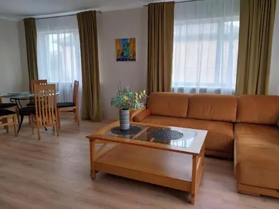 a living room with a couch and a table at Saulės miesto apartamentai in Šiauliai