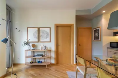 a living room with a glass table and wooden floors at 2 Bedroom Apt with Balconies in Druskininkai