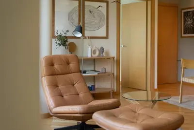 a living room with a chair and a glass table at 2 Bedroom Apt with Balconies in Druskininkai