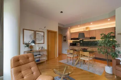 a living room and kitchen with a table and chairs at 2 Bedroom Apt with Balconies in Druskininkai