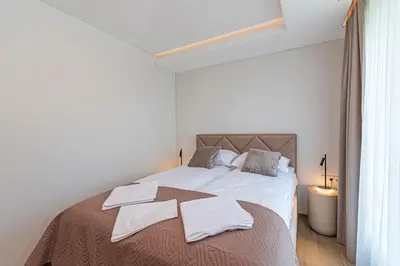 a white bedroom with a bed with towels on it at Modern 2 BD Apartment by Domvia in Kaunas