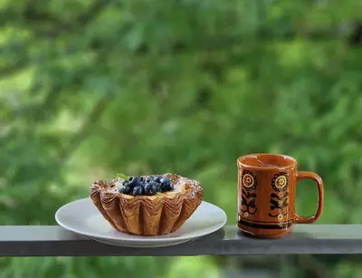 a cup of coffee and a pastry on a plate next to a mug at L18 Apartamentai in Kaunas
