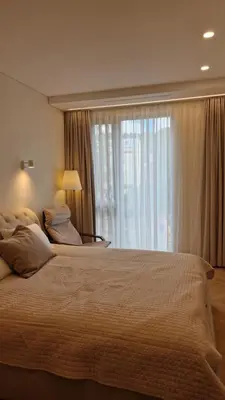 a bedroom with a large bed with a large window at L18 Apartamentai in Kaunas