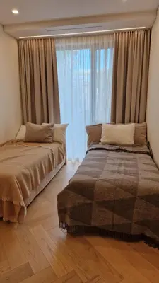 a bedroom with two beds and a large window at L18 Apartamentai in Kaunas