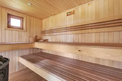 a sauna with wooden paneling and a window at Žalesos pirtelė in Ažulauke