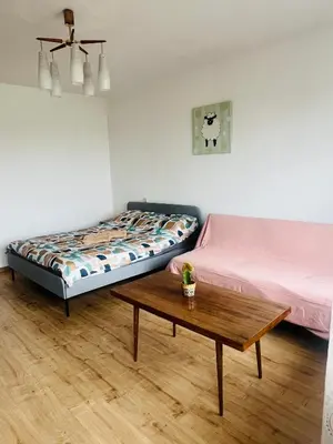 a room with two beds and a coffee table at Žaliakalnio panoramos apartamentai in Kaunas