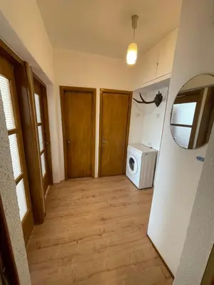 a hallway with a laundry room with a washer and dryer at Žaliakalnio panoramos apartamentai in Kaunas