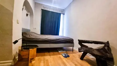 a bedroom with a bed with a blue curtain and a window at Artsy Retreat In The Heart Of Uzupis, Vilnius in Vilnius