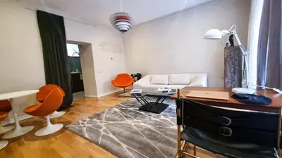 a living room with a white couch and orange chairs at Artsy Retreat In The Heart Of Uzupis, Vilnius in Vilnius