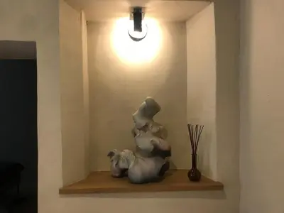 a white statue sitting on a shelf with a light at Artsy Retreat In The Heart Of Uzupis, Vilnius in Vilnius