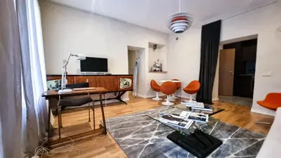 a living room with a desk and orange chairs at Artsy Retreat In The Heart Of Uzupis, Vilnius in Vilnius