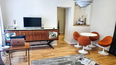 a living room with orange chairs and a tv at Artsy Retreat In The Heart Of Uzupis, Vilnius in Vilnius