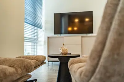 a living room with two chairs and a table and a tv at Studija 17 butai in Kaunas
