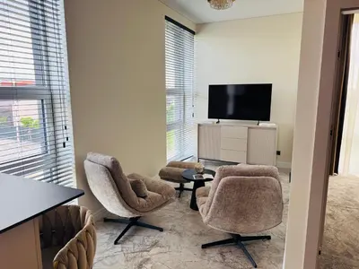 a living room with two chairs and a tv at Studija 17 butai in Kaunas