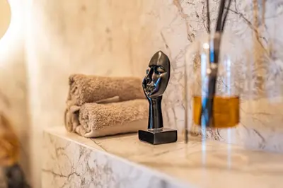a statue of a face on a shelf with towels at Studija 17 butai in Kaunas