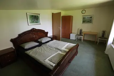 a bedroom with a large wooden bed in a room at Poilsiavietė - kempingas ''Viktorija''