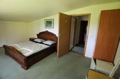 a bedroom with a bed and an open door at Poilsiavietė - kempingas ''Viktorija''