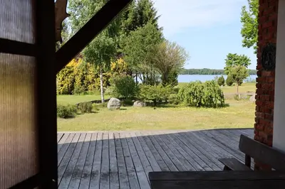 a door to a porch with a view of a park at Poilsiavietė - kempingas ''Viktorija''