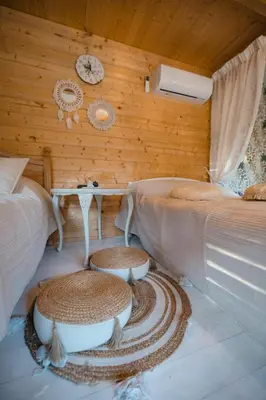 a room with two beds and a table and a wall at Vila Skodupė