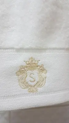 a white mattress with a gold embroidery on it at Vila Skodupė