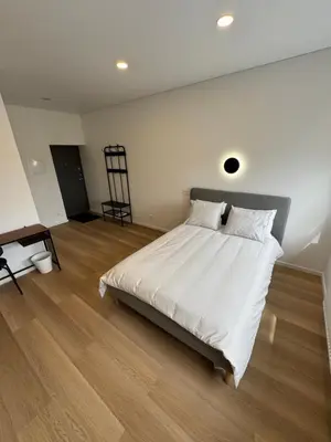 a bedroom with a large white bed and wooden floors at 10 New Airport Apartment in VNO