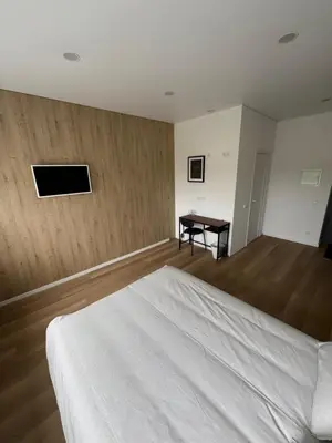 a bedroom with a white bed and a desk at 10 New Airport Apartment in VNO