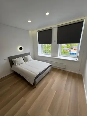 a bedroom with a bed and two windows at 10 New Airport Apartment in VNO