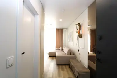 a hallway with a living room with a couch and a table at Flat for 2 or 1 with Free Parking and Fast Wi-Fi in Vilnius