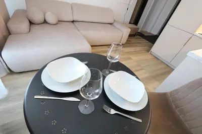 a black table with white plates and wine glasses on it at Flat for 2 or 1 with Free Parking and Fast Wi-Fi in Vilnius