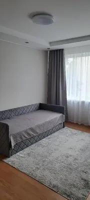 a bedroom with a bed with a rug and a window at Apartamentai The 56 Spot in Utena
