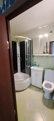 a bathroom with a tub and a toilet and a sink at Apartamentai The 56 Spot in Utena