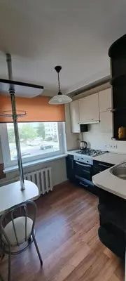 a kitchen with a table and a chair in it at Apartamentai The 56 Spot in Utena