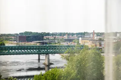 a bridge over a river with a city in the background at CityView Kaunas Center in Kaunas