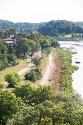 a person walking down a road next to a river at CityView Kaunas Center in Kaunas