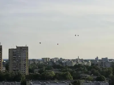 a city with buildings and birds flying in the sky at Apartaments Kaunas in Kaunas