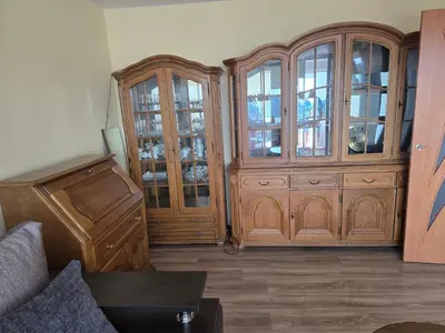 a living room with two wooden cabinets and a couch at Apartaments Kaunas in Kaunas