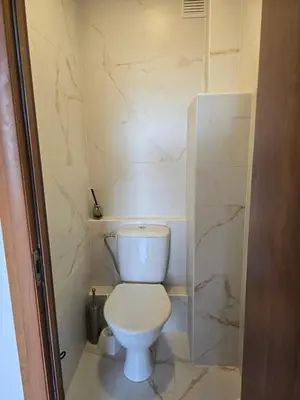 a white toilet in a bathroom with marble walls at Apartaments Kaunas in Kaunas