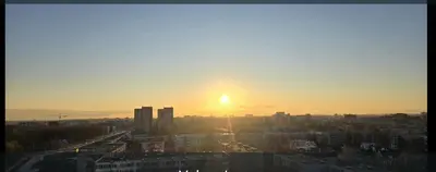 a city skyline with the sun setting in the sky at Apartaments Kaunas in Kaunas